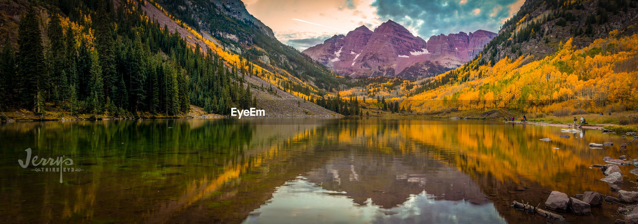 Scenic view of lake by mountains against sky