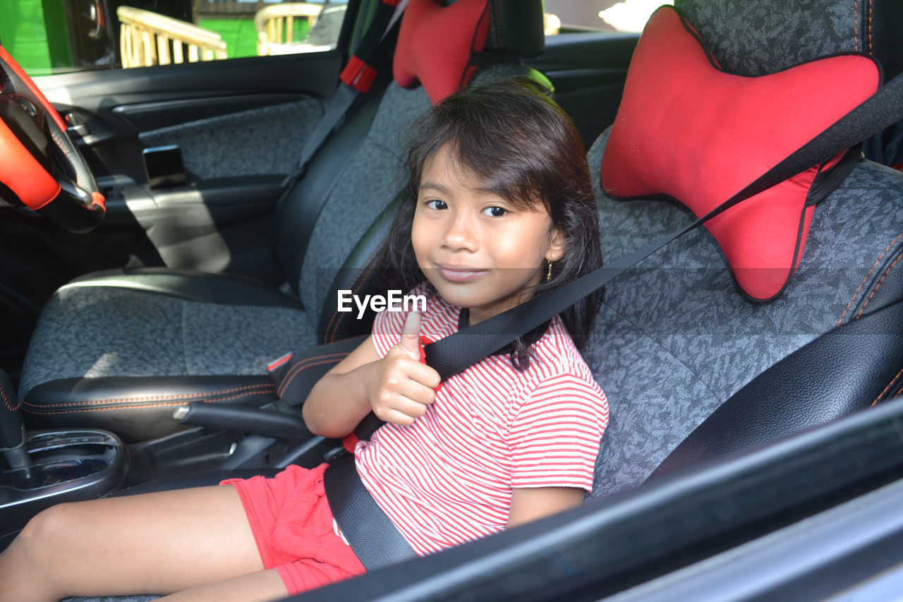 Portrait of cute girl sitting in car