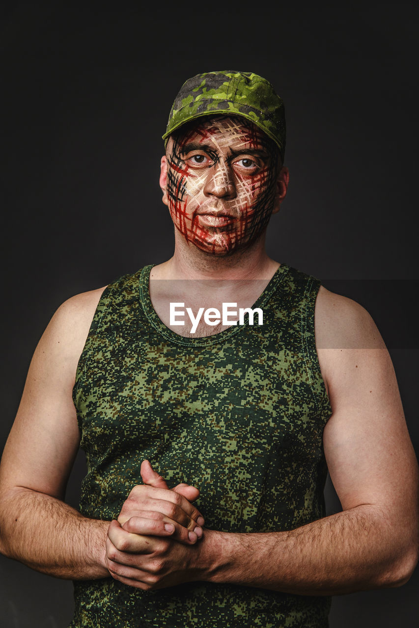Portrait of soldier against black background