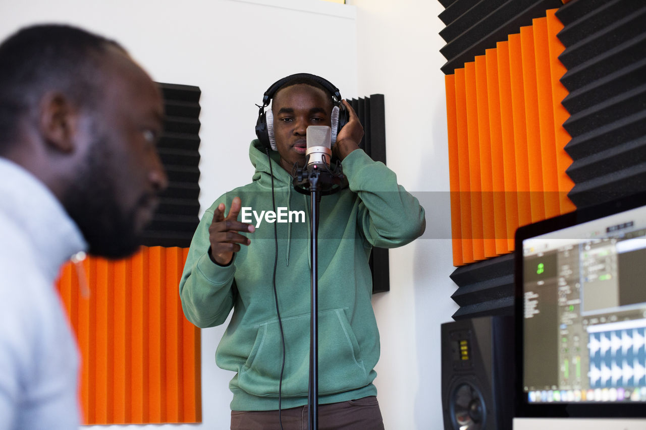 Rapper and sound engineer recording song in studio
