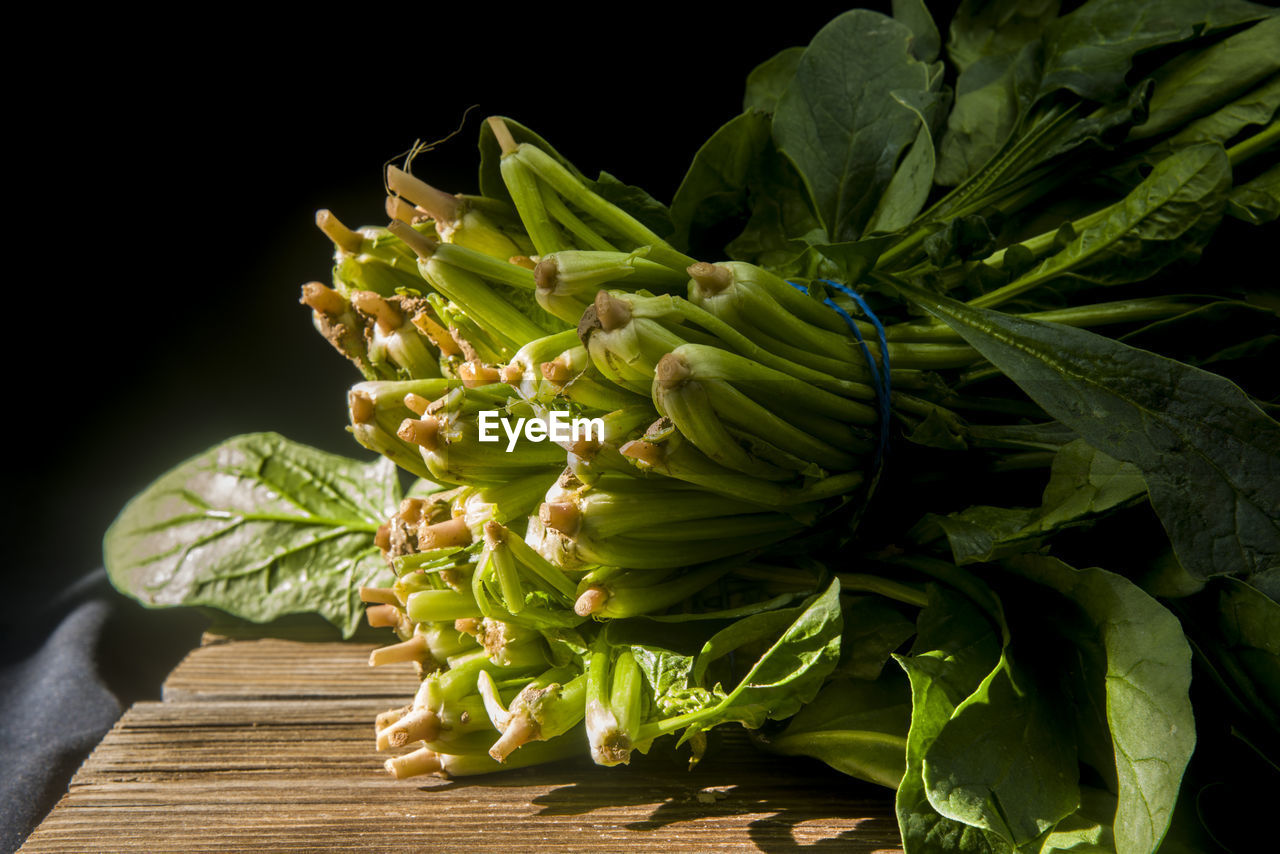 Close-up of spinachs on table against black background