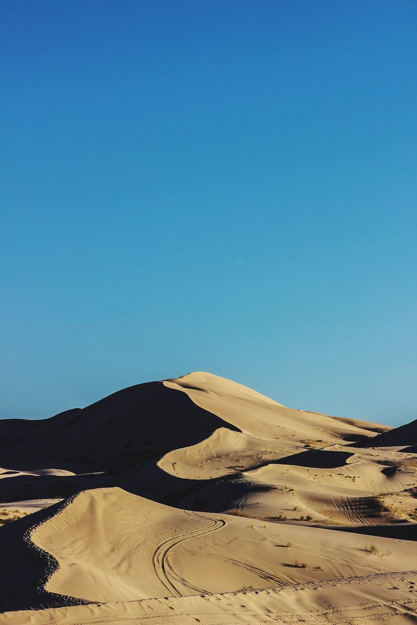 Scenic view of desert against clear blue sky