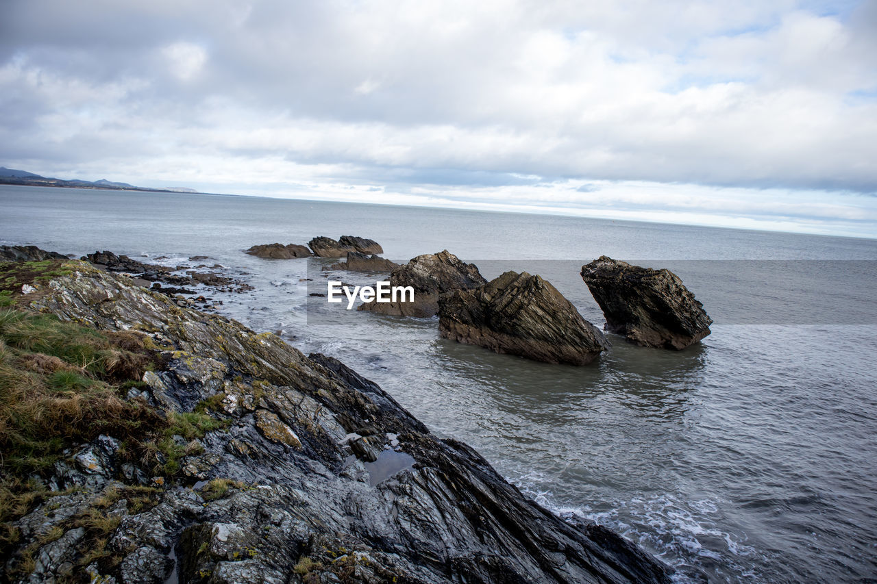 Scenic view of rocks in sea against sky