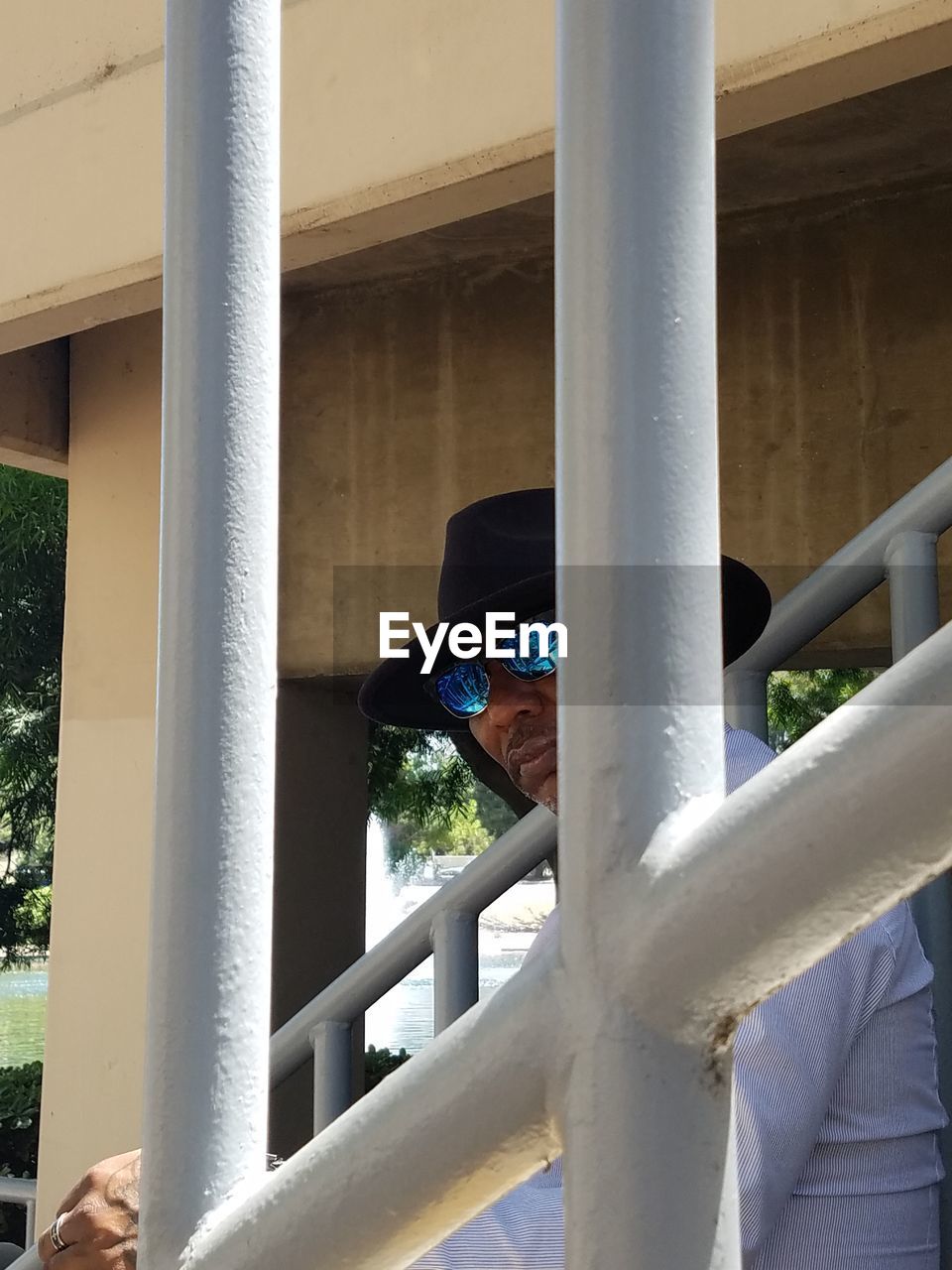 Man in sunglasses seen through railing