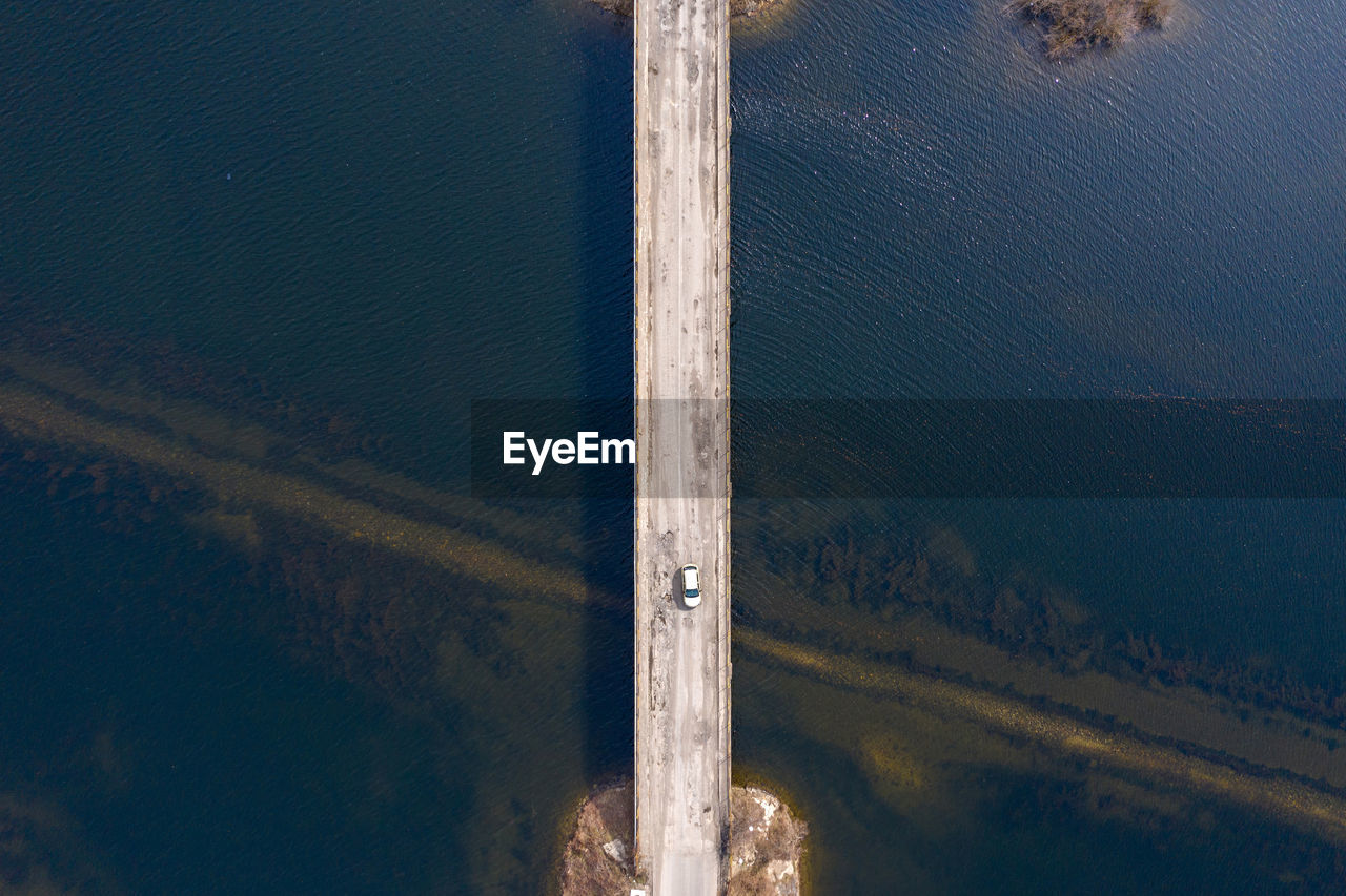 Aerial view of car on bridge over lake