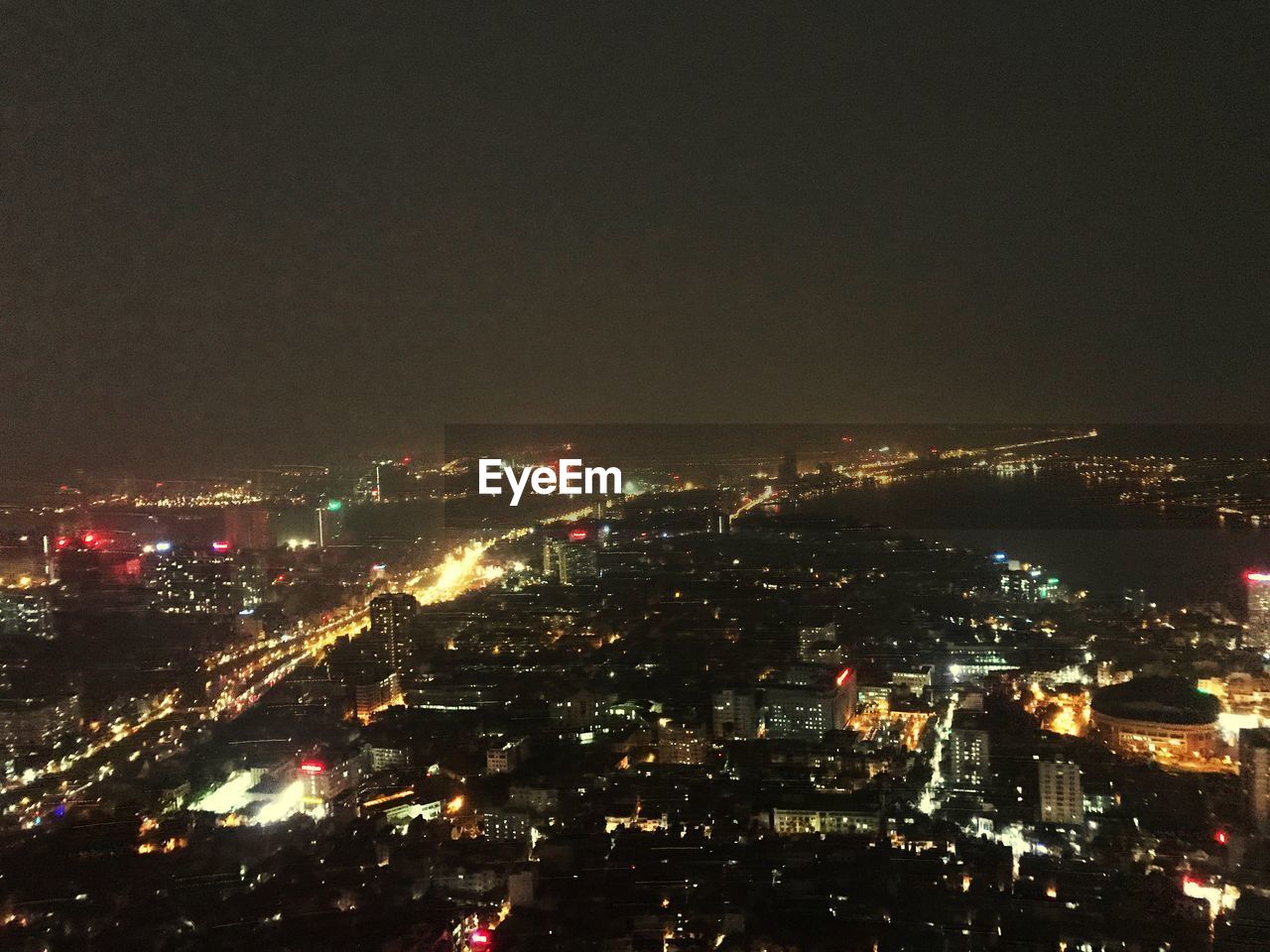 HIGH ANGLE VIEW OF ILLUMINATED CITY BUILDINGS AT NIGHT