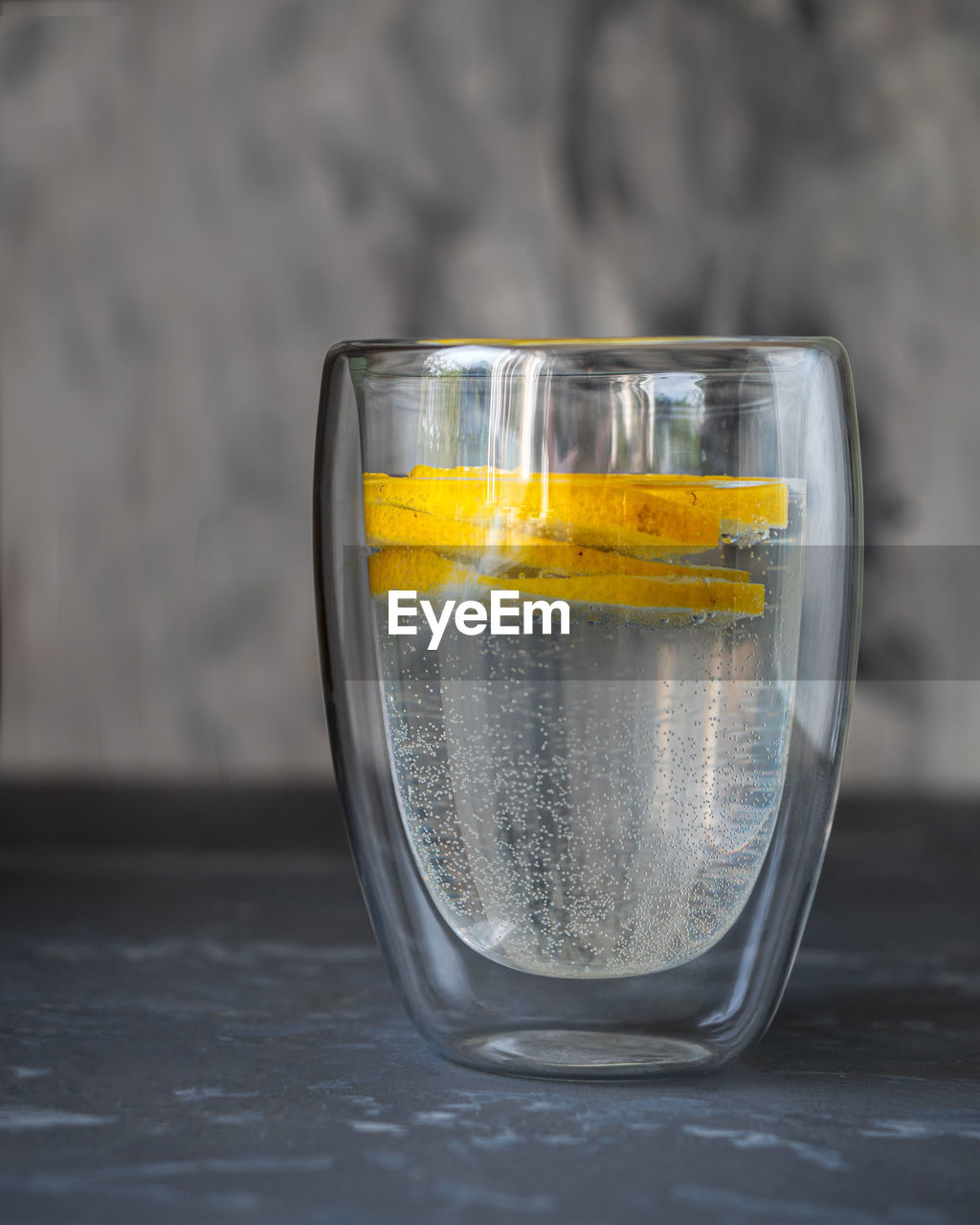 Refreshing drink for a hot day with mineral water and lemon in a glass glass close-up