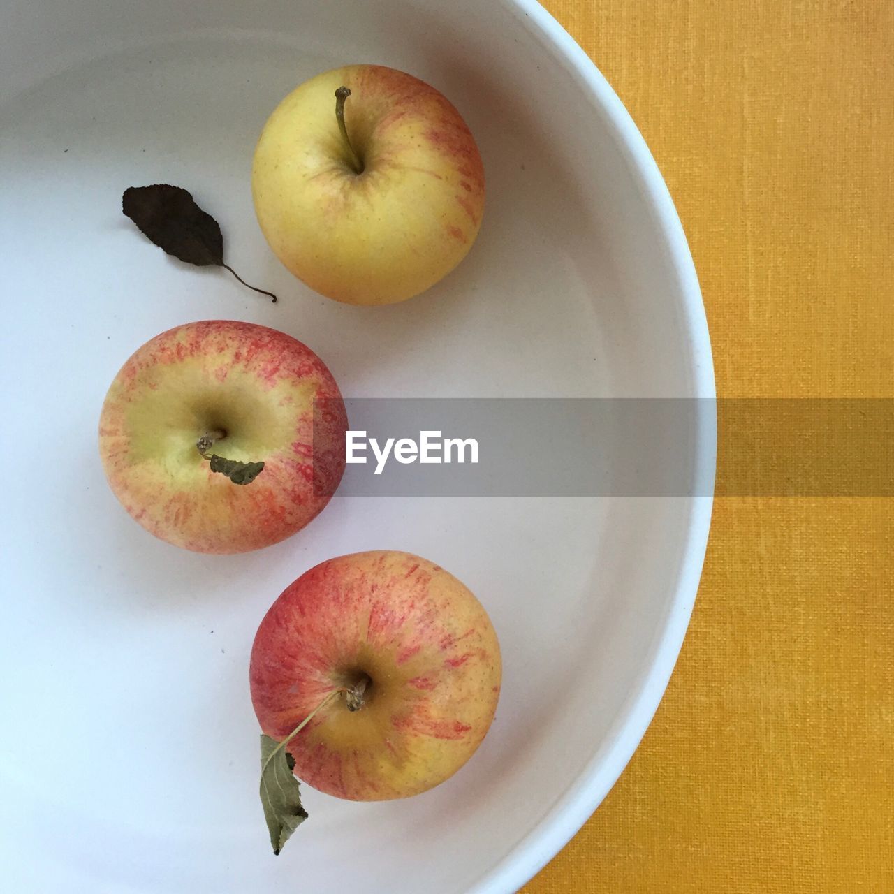 HIGH ANGLE VIEW OF APPLES IN PLATE ON TABLE