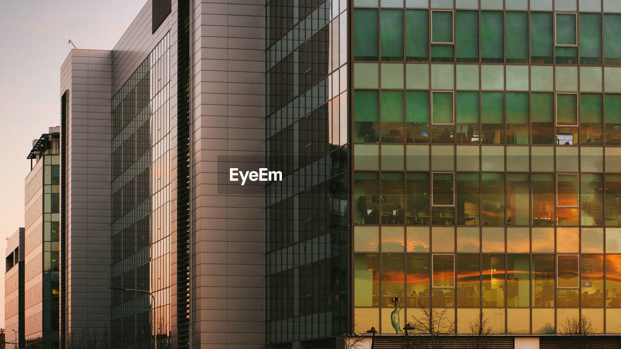 Low angle view of glass building against sky