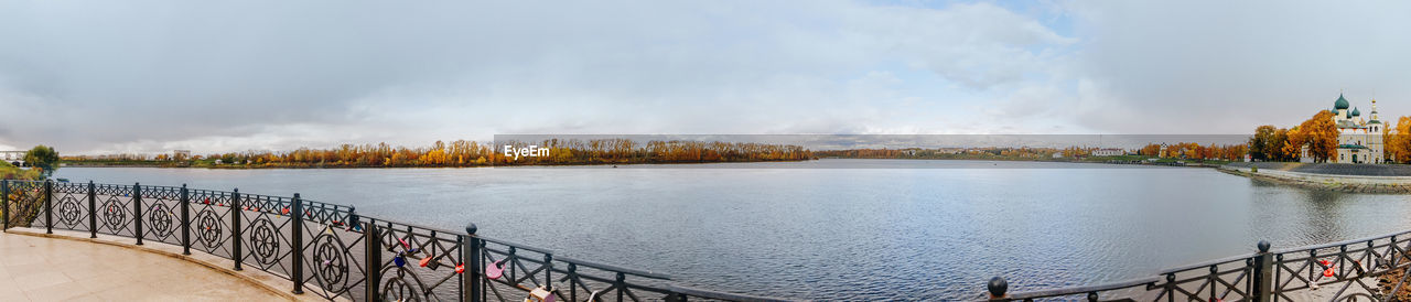 Beautiful lake and yellow trees in an autumn cloudy day. panoramic landscape.