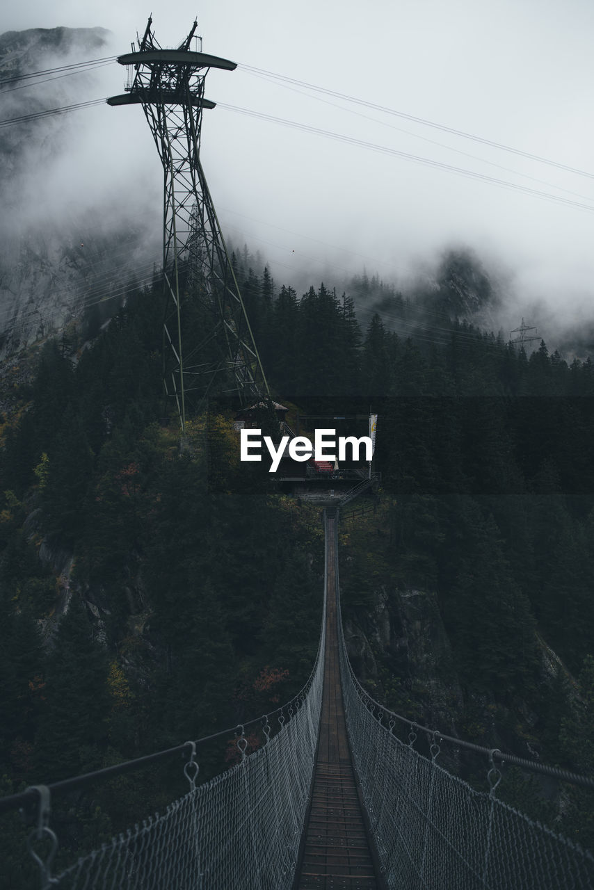 Bridge and electricity pylon during foggy weather