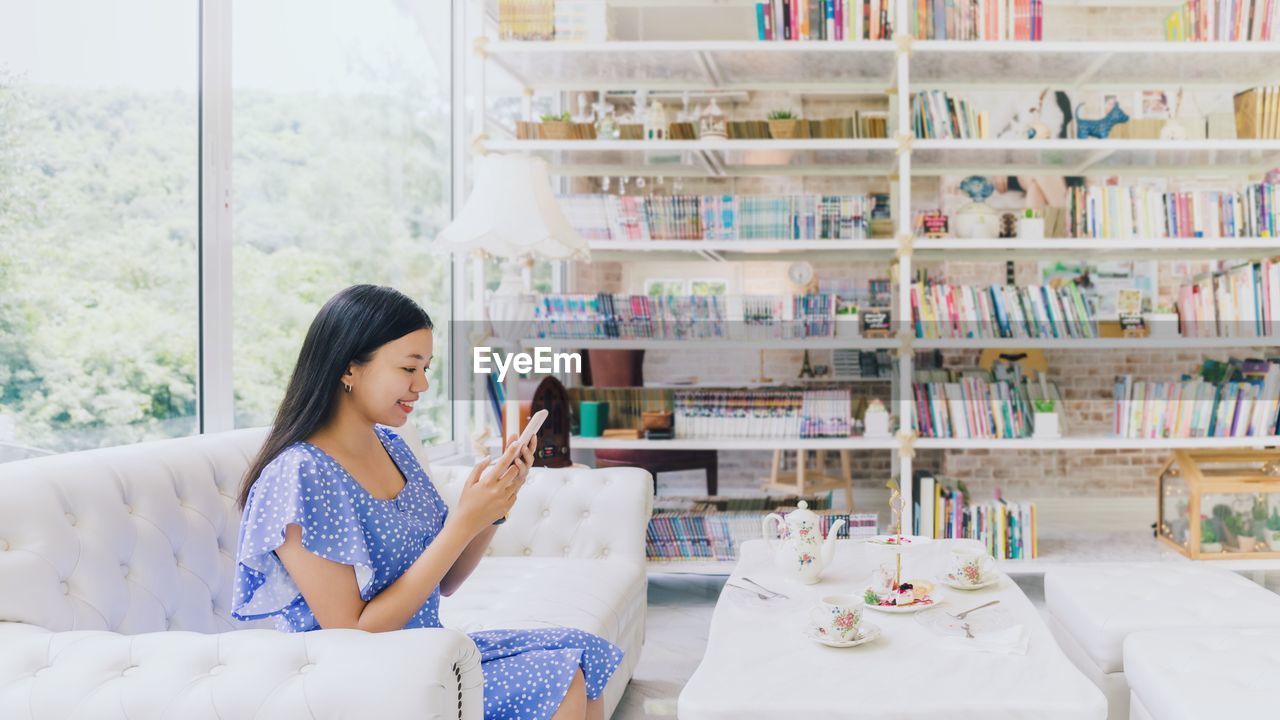 WOMAN SITTING ON BOOK