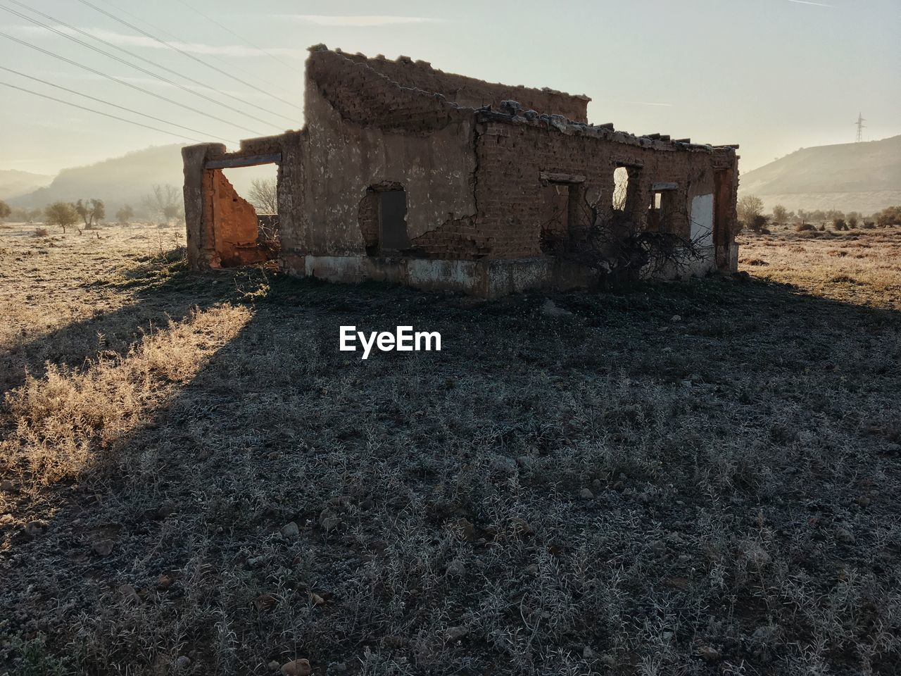 OLD BUILDING ON FIELD AGAINST SKY