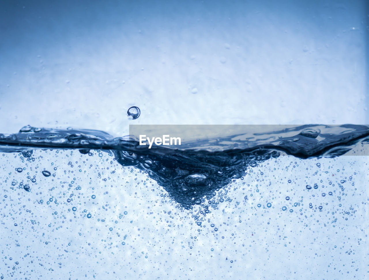 CLOSE-UP OF WATER DROPS ON BLUE SURFACE