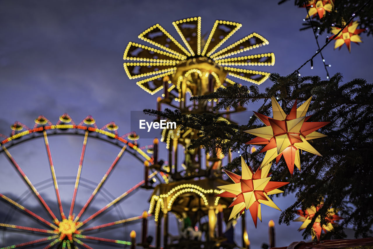 LOW ANGLE VIEW OF ILLUMINATED FERRIS WHEEL AGAINST SKY