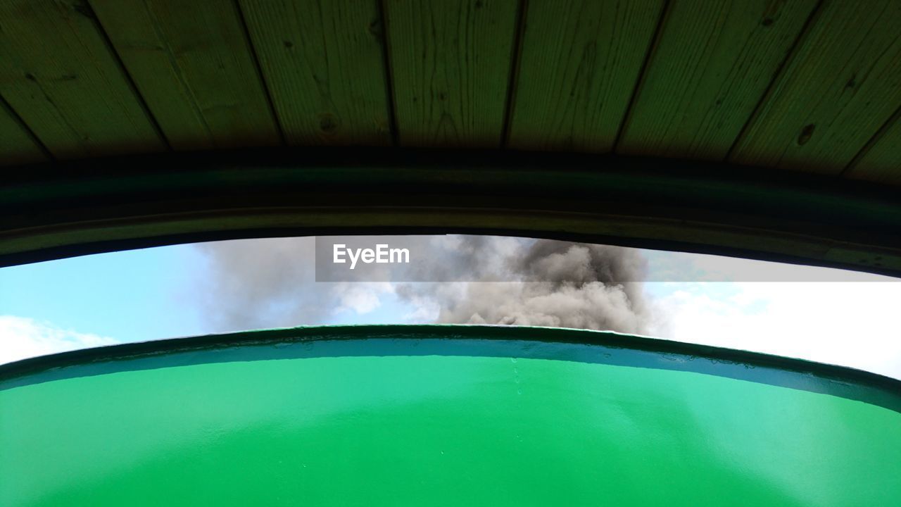 Low angle view of smoke emitting from train against sky on sunny day