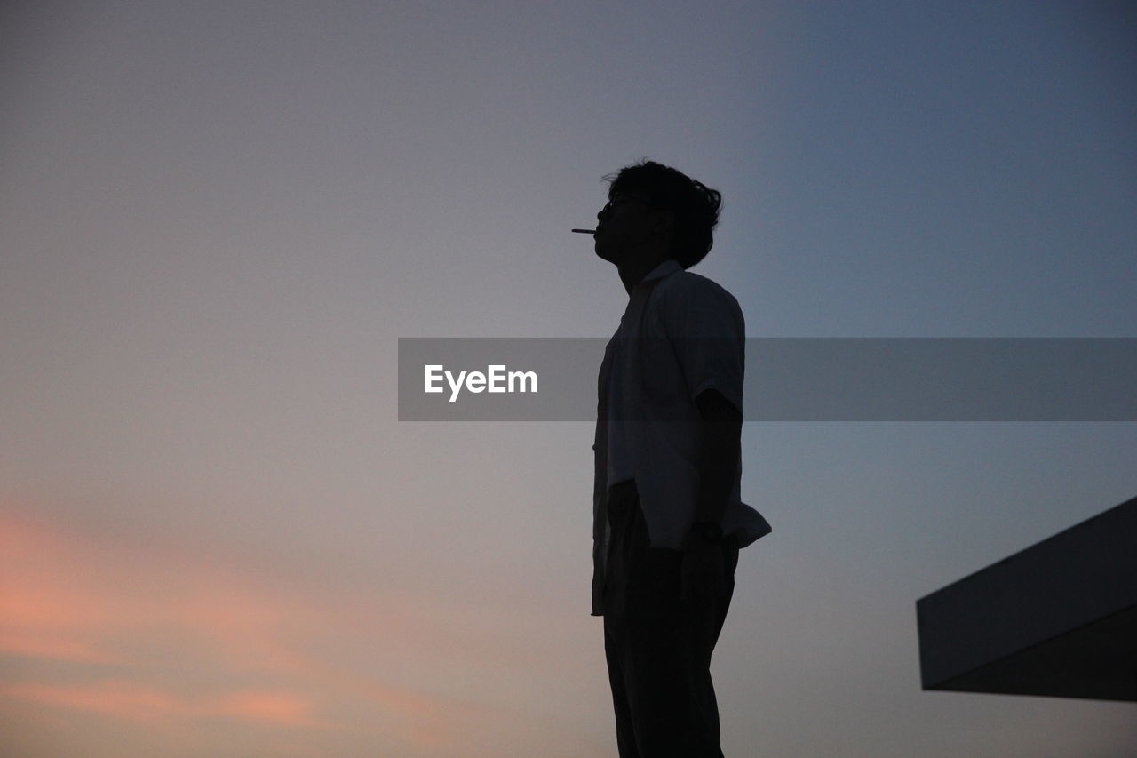 low angle view of silhouette man standing against sky during sunset