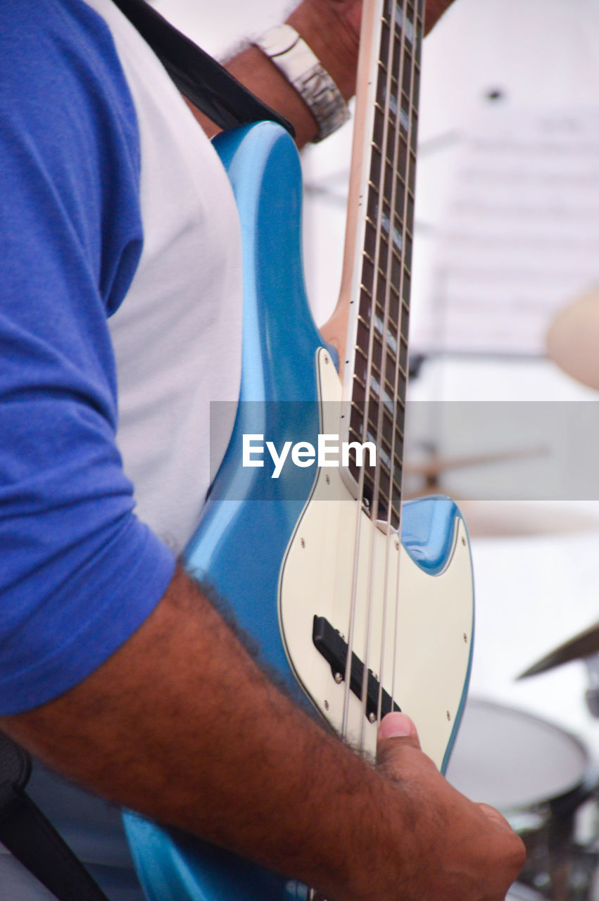 Midsection of man playing guitar