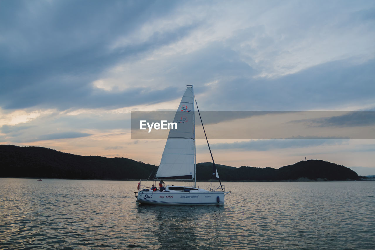 SAILBOAT SAILING IN SEA AGAINST SKY