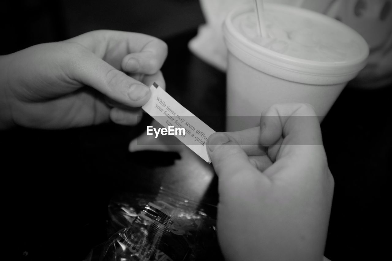 Cropped hand holding message on paper at restaurant