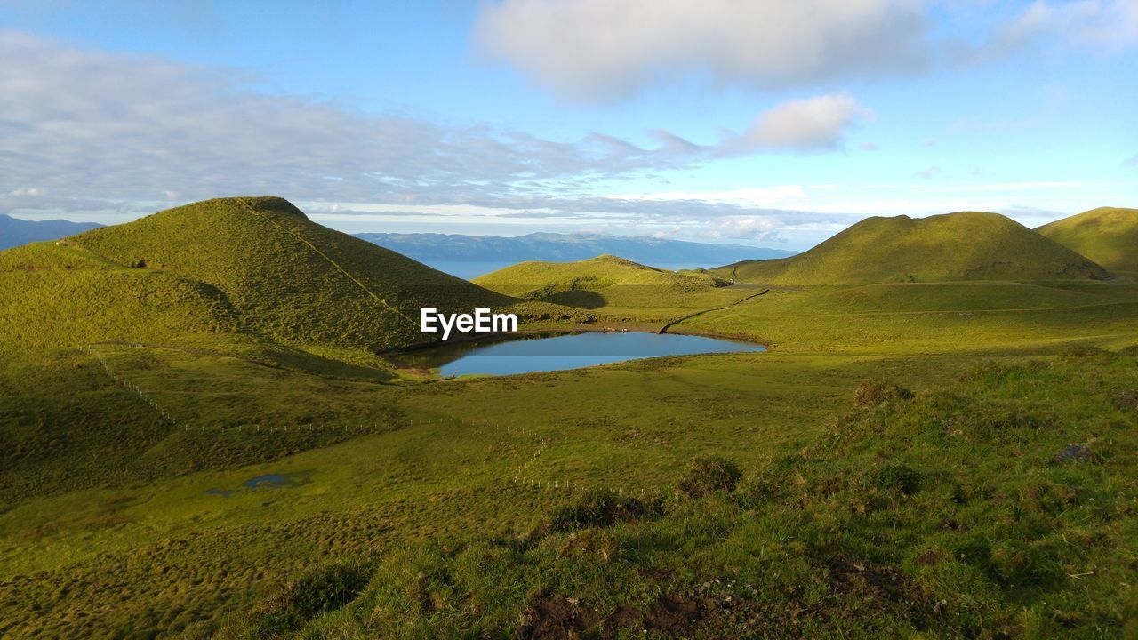 Scenic view of lake and mountains at pico island against sky