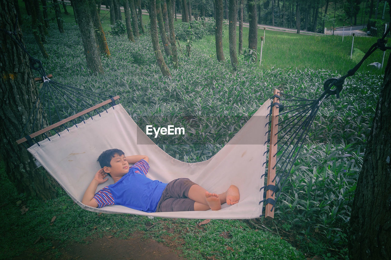 View of boy relaxing in hammock