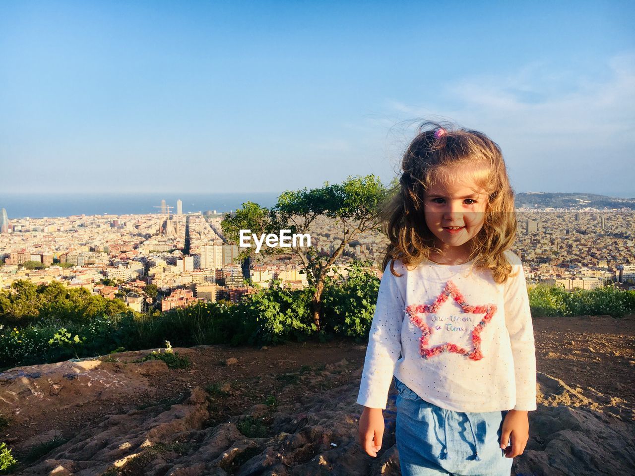 Portrait of cute girl standing against cityscape