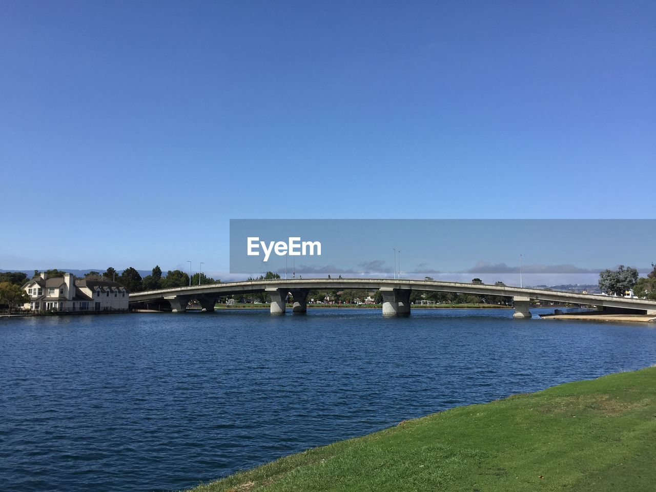 Bridge over river against clear blue sky