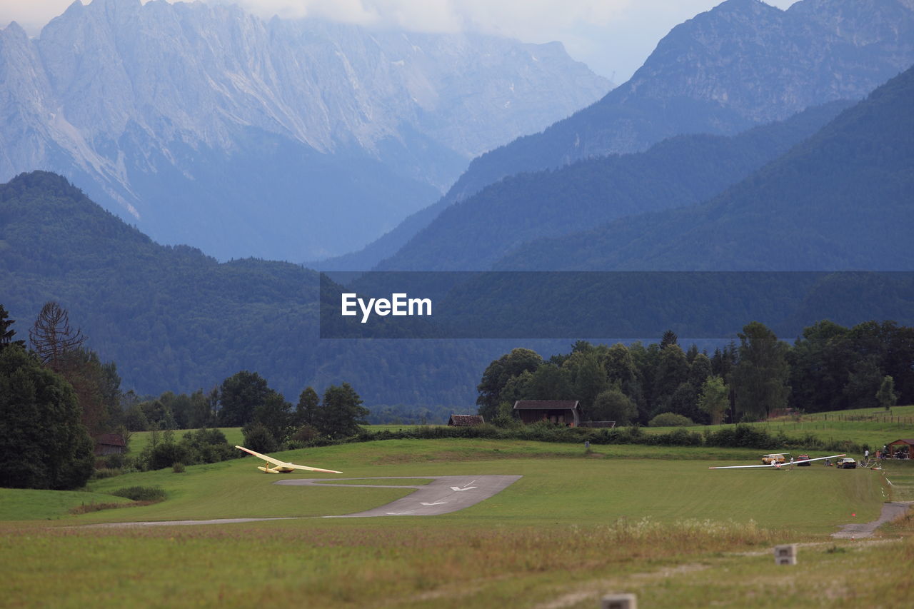 Scenic view of field and mountains against sky