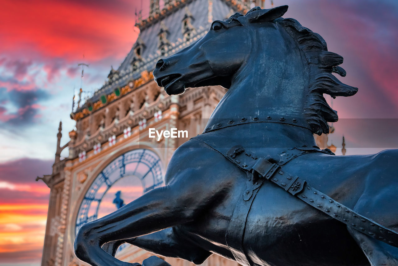 Close up view of the big ben clock tower and horse statue monument in the foreground.