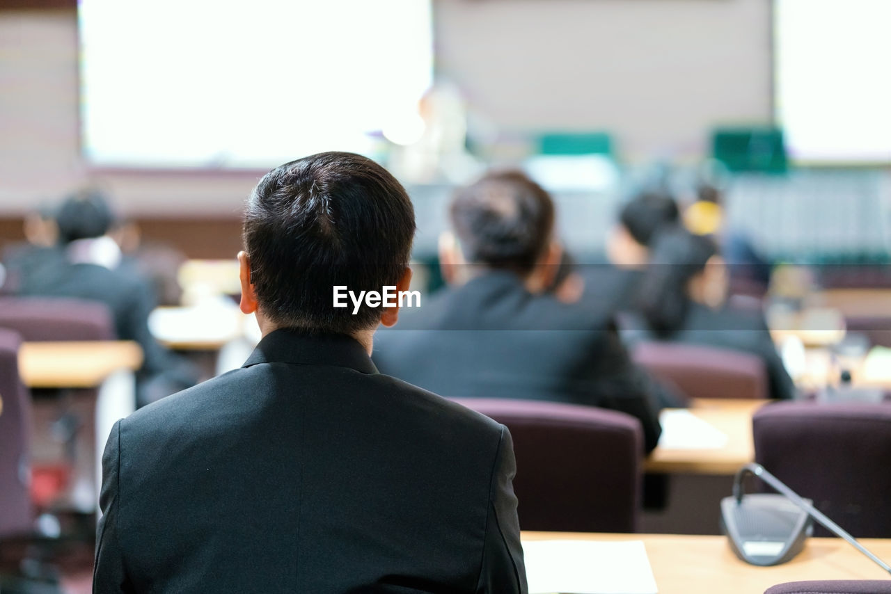 Rear view of businessman sitting at desk