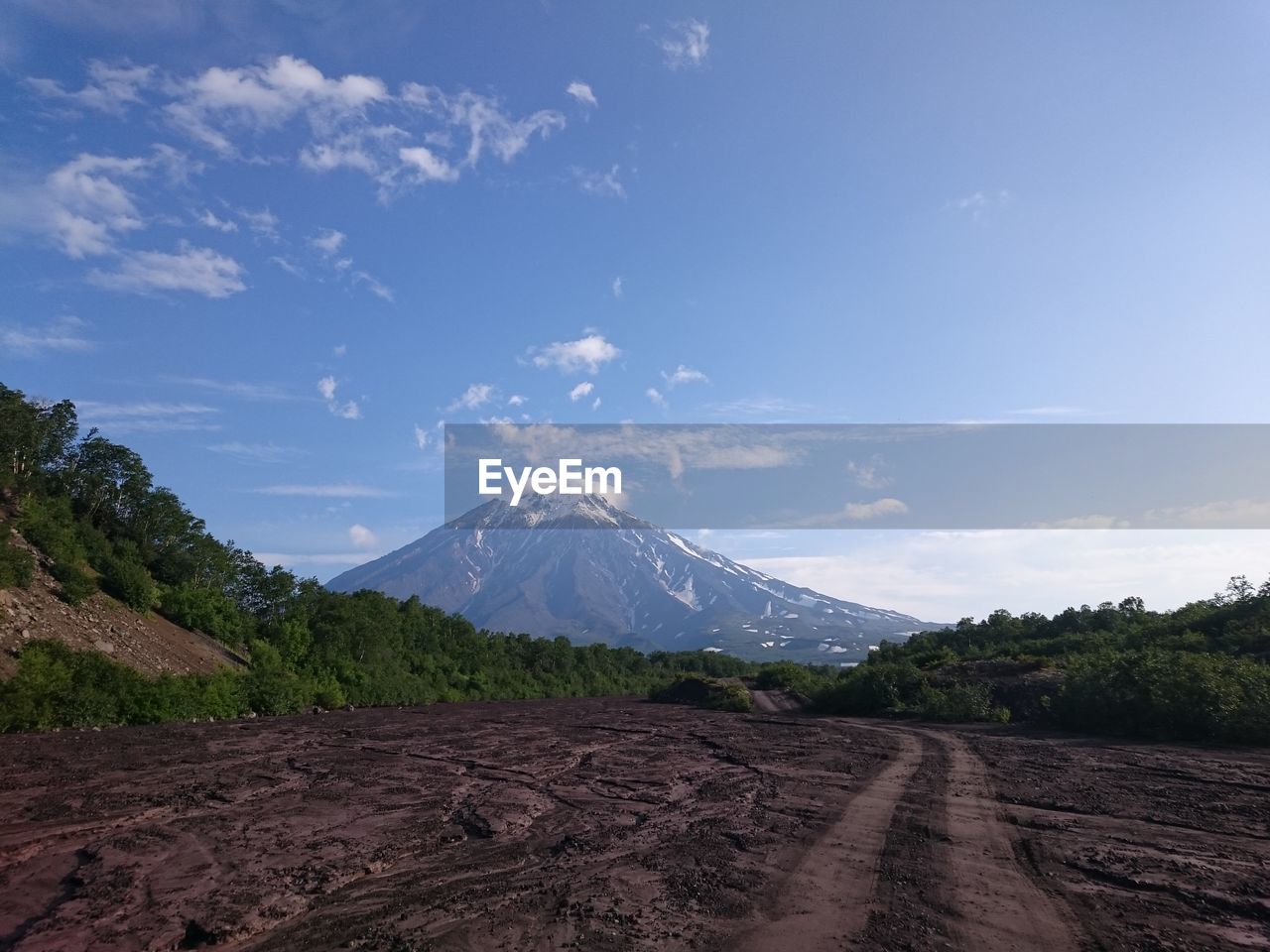 Road leading towards mountains against sky