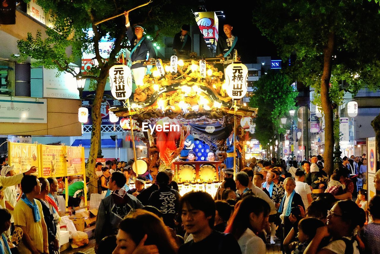 GROUP OF PEOPLE IN FRONT OF BUILDING AT NIGHT