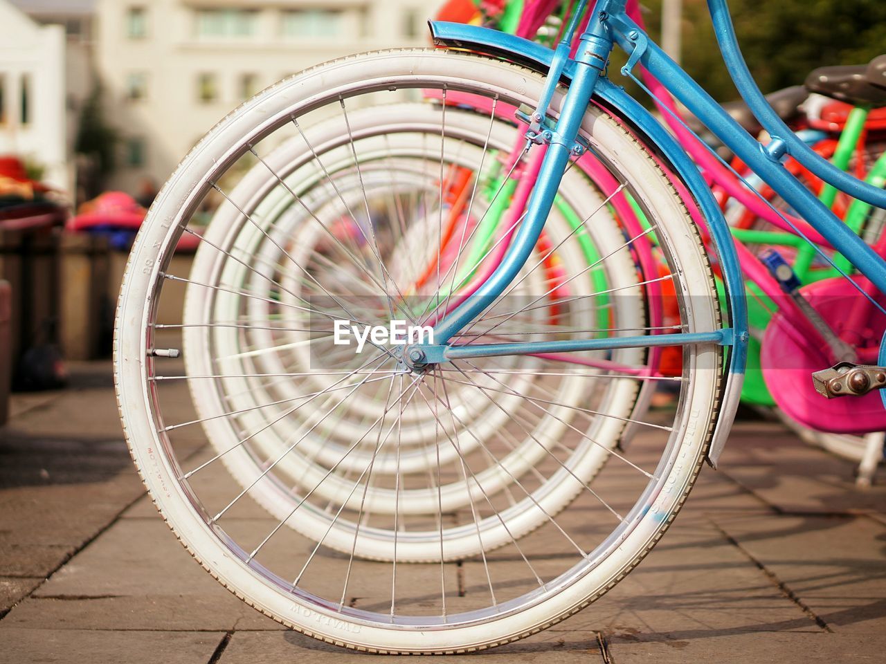 Colorful bicycles parked in row on footpath