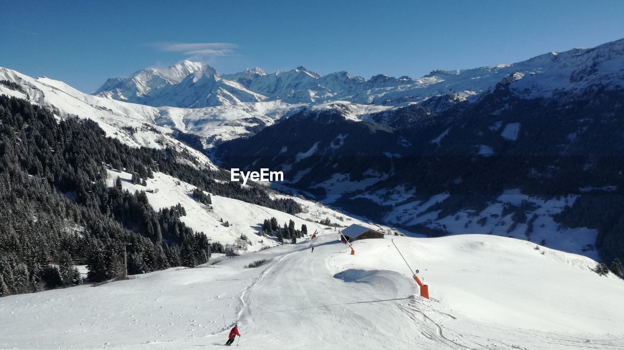 View of people skiing on snow covered mountain