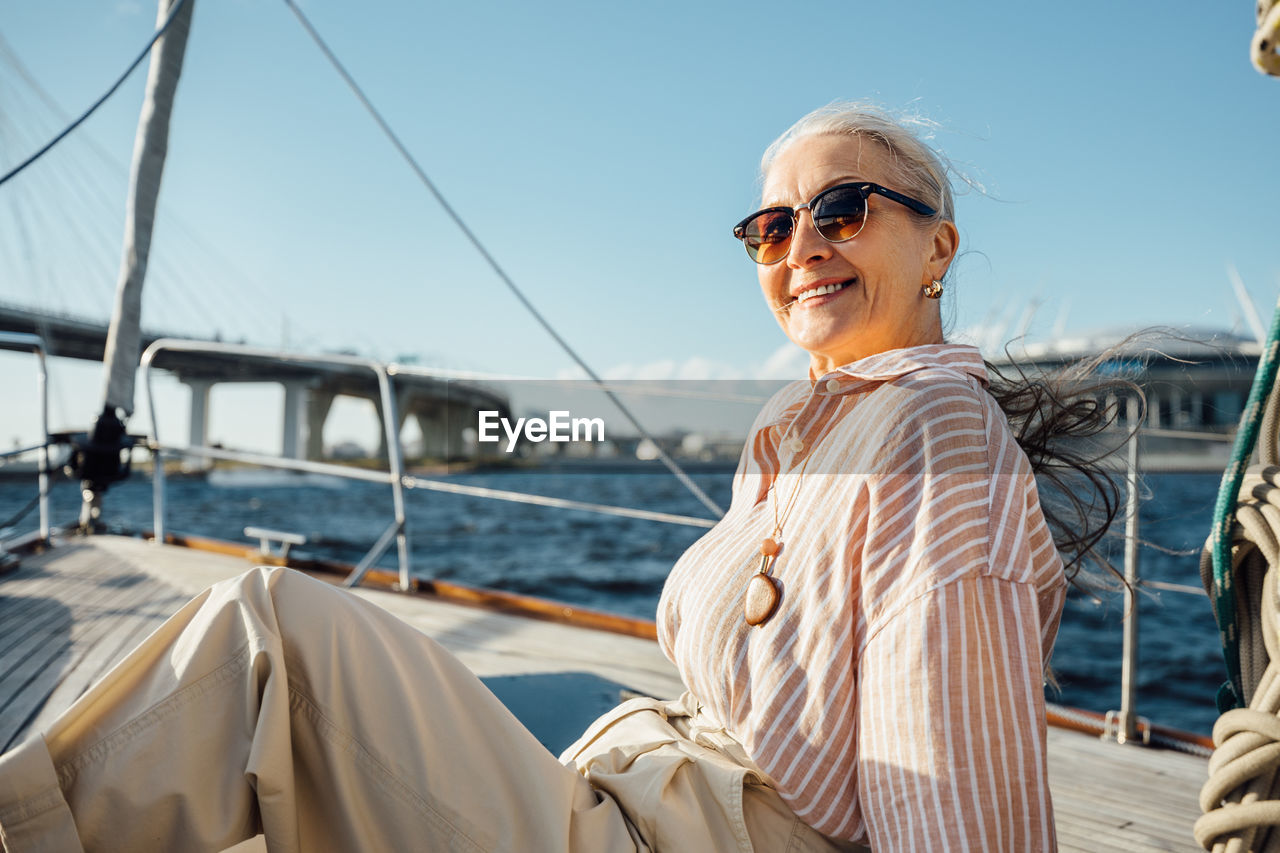 Woman standing on boat in sea against sky