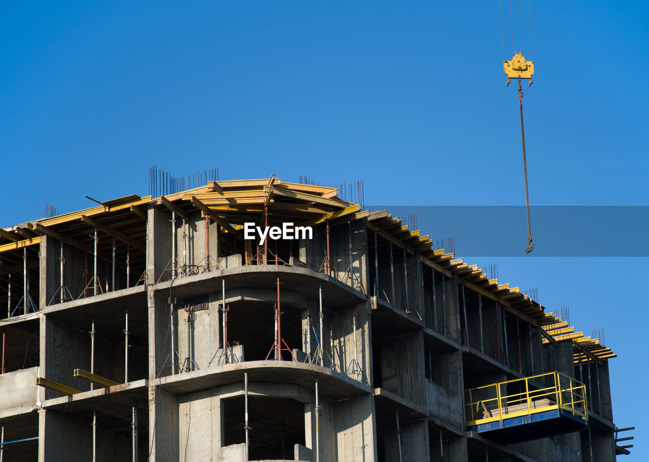 LOW ANGLE VIEW OF BUILDINGS AGAINST BLUE SKY