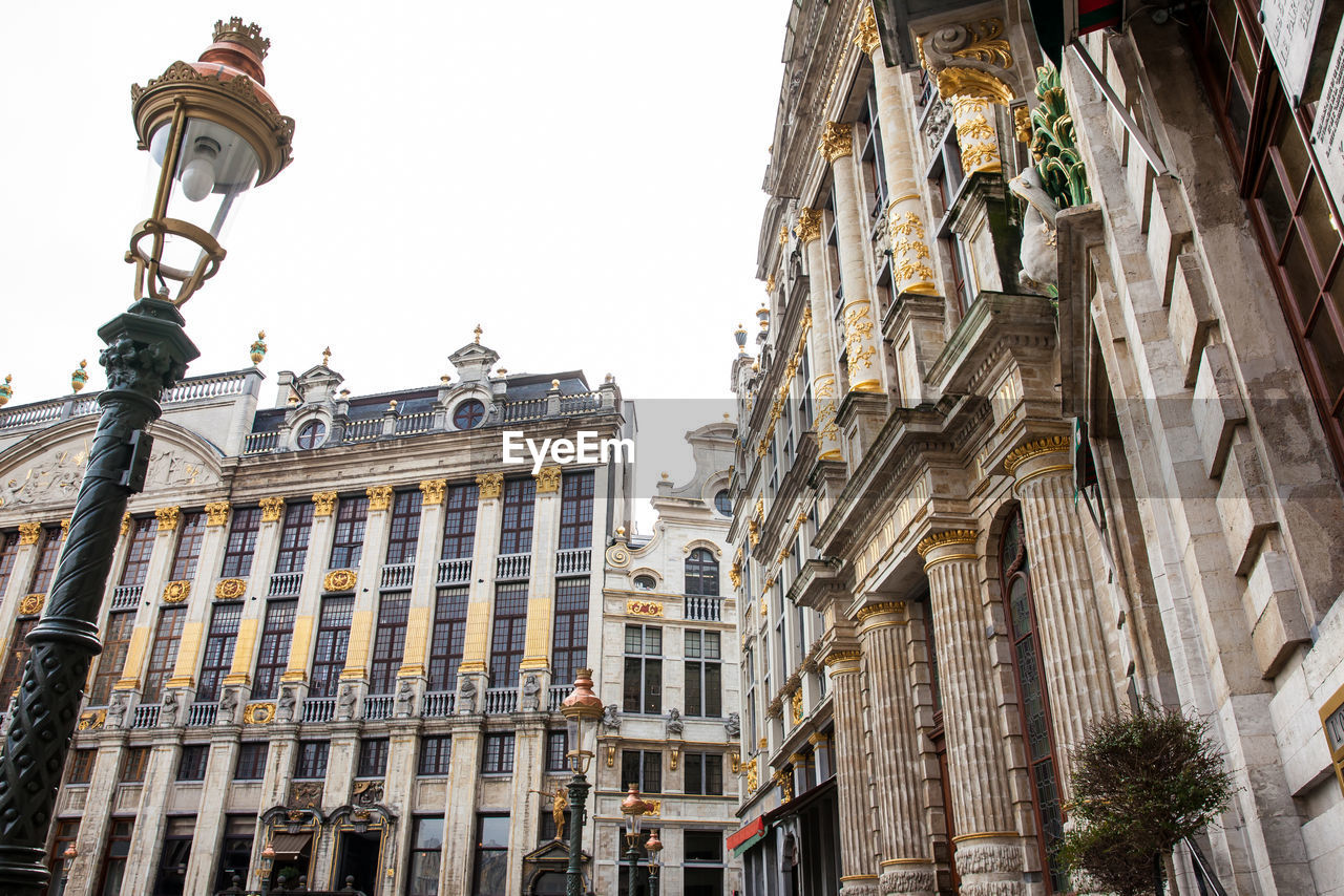 LOW ANGLE VIEW OF STREET LIGHT AGAINST BUILDINGS