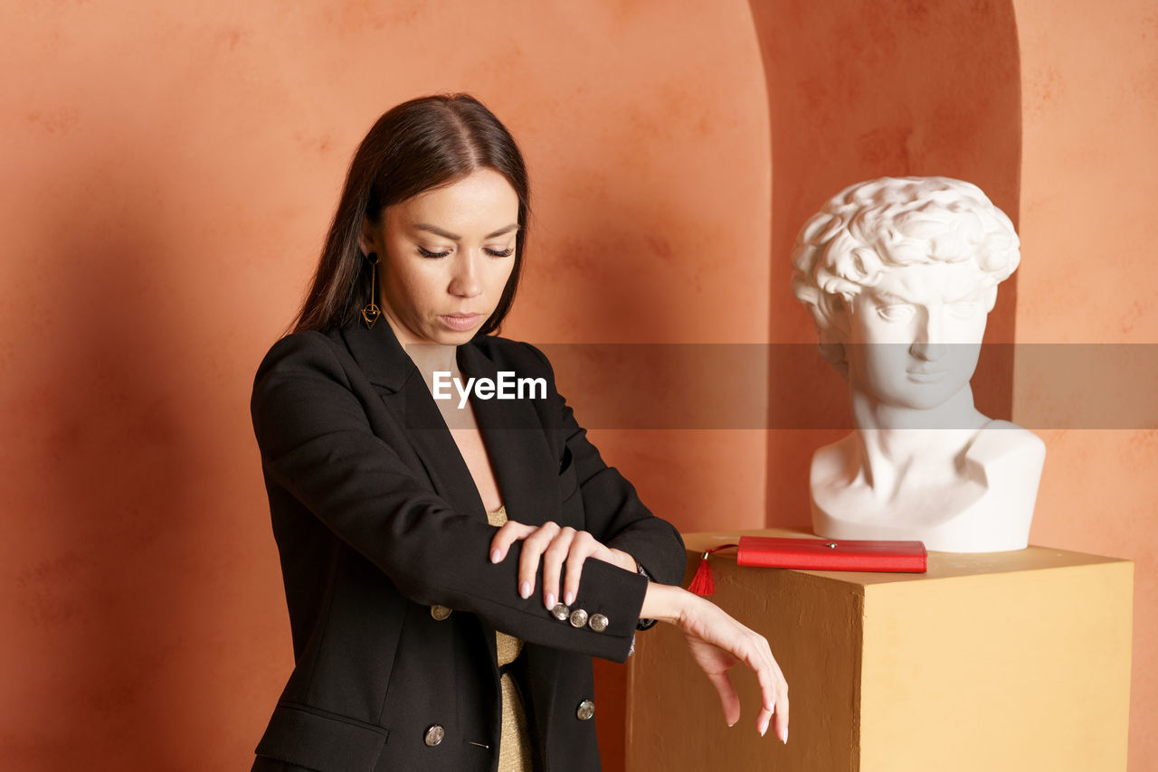 Portrait of happy smiling brunette businesswoman in black jacket and golden