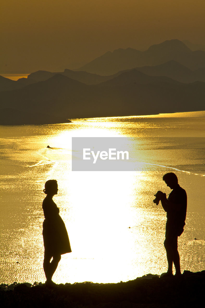 Full length of a silhouette couple on beach