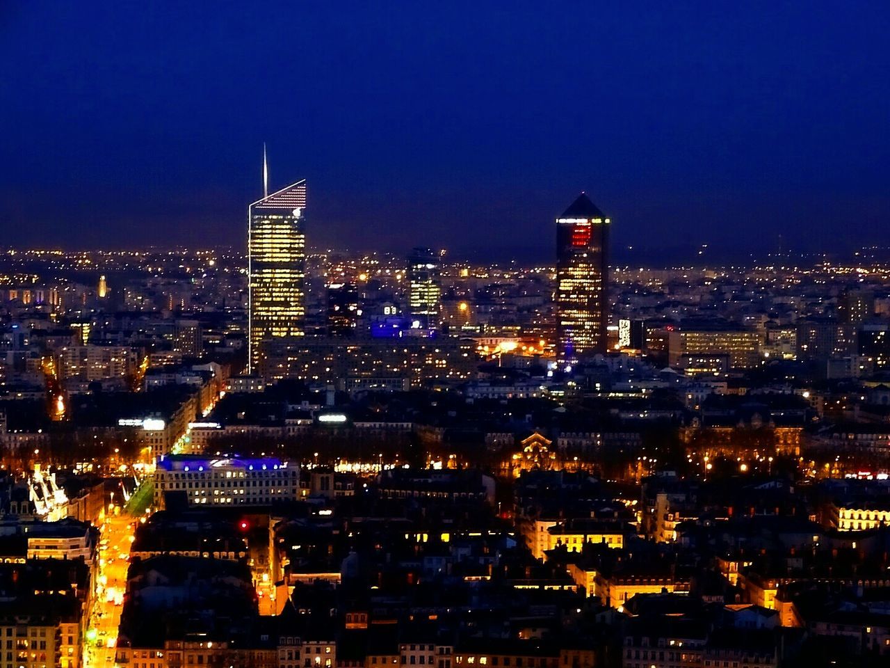 Illuminated cityscape against sky at night