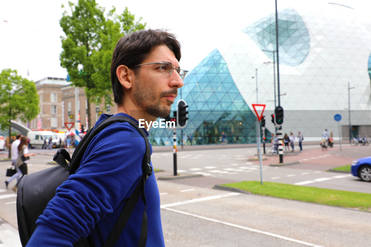 Side view of man looking away in city