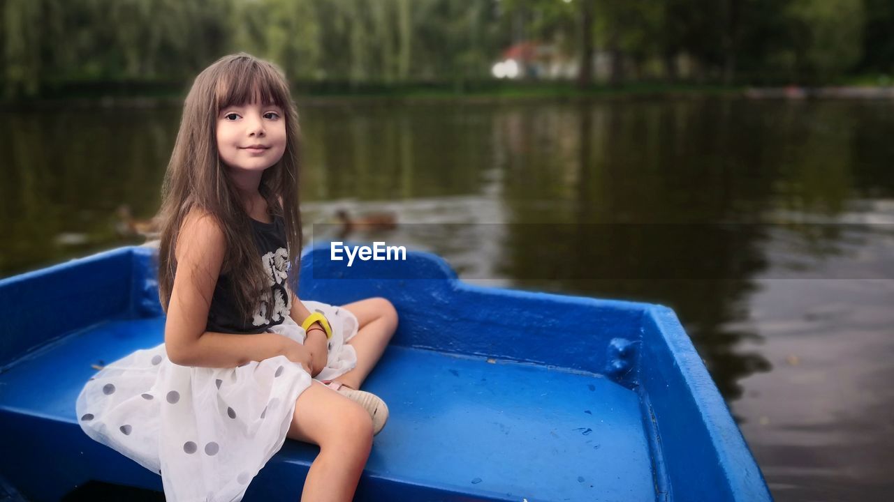 Girl sitting in boat on lake