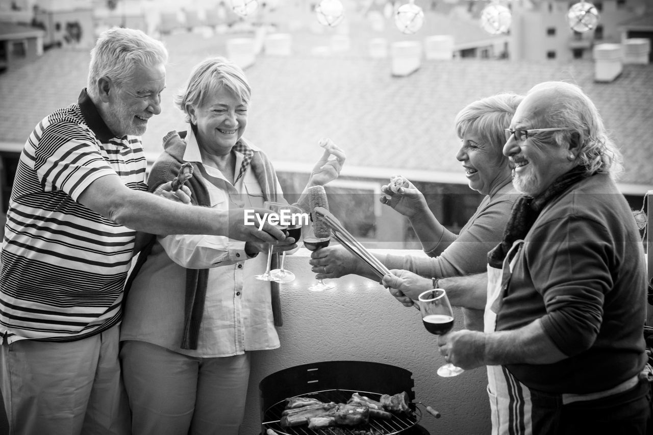 Happy couple toasting wineglasses against sky