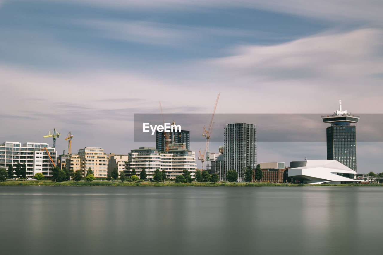 Modern buildings in city against sky amsterdam skyline eye museum long exposure