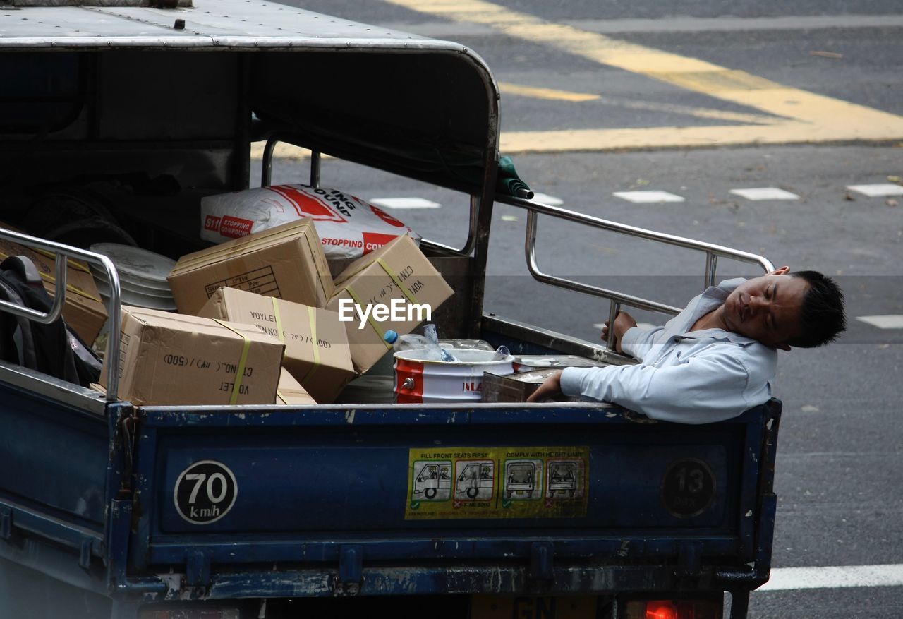 FULL LENGTH OF MAN SITTING ON STREET