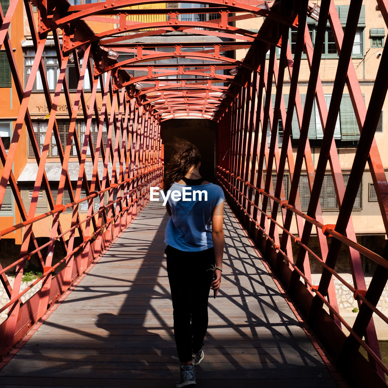 Rear view of woman walking on footbridge