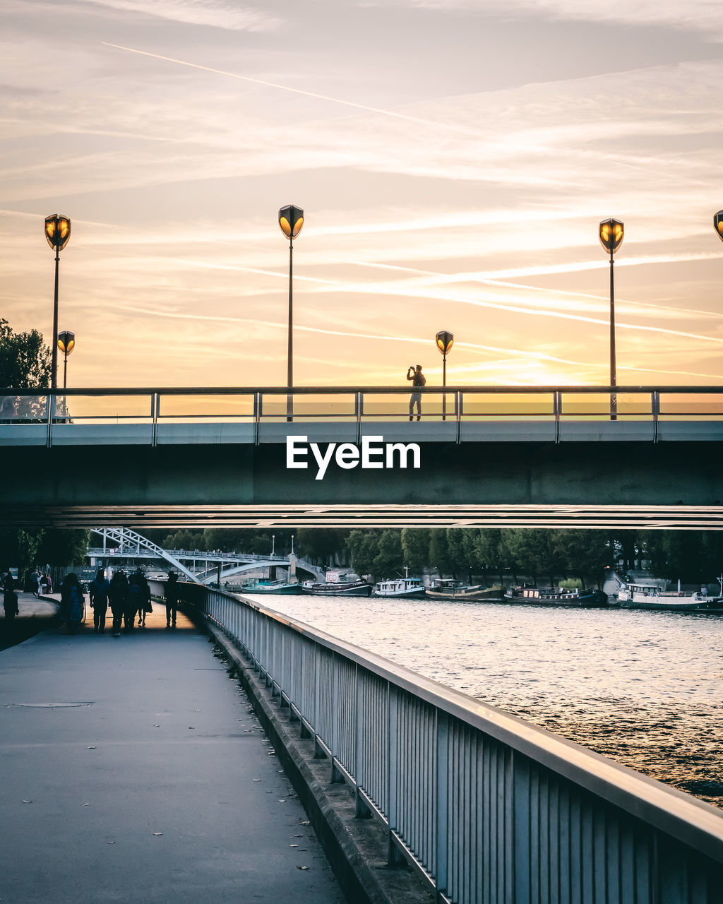 Bridge over river against sky during sunset