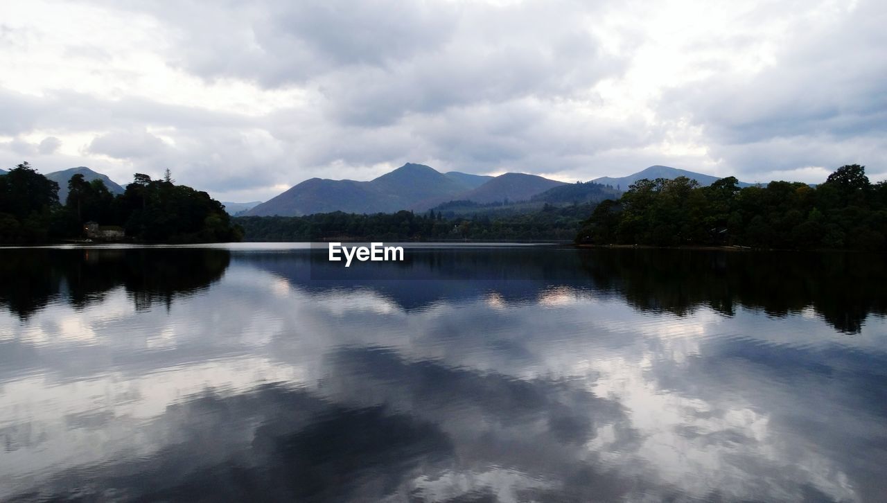 Scenic view of calm lake against cloudy sky