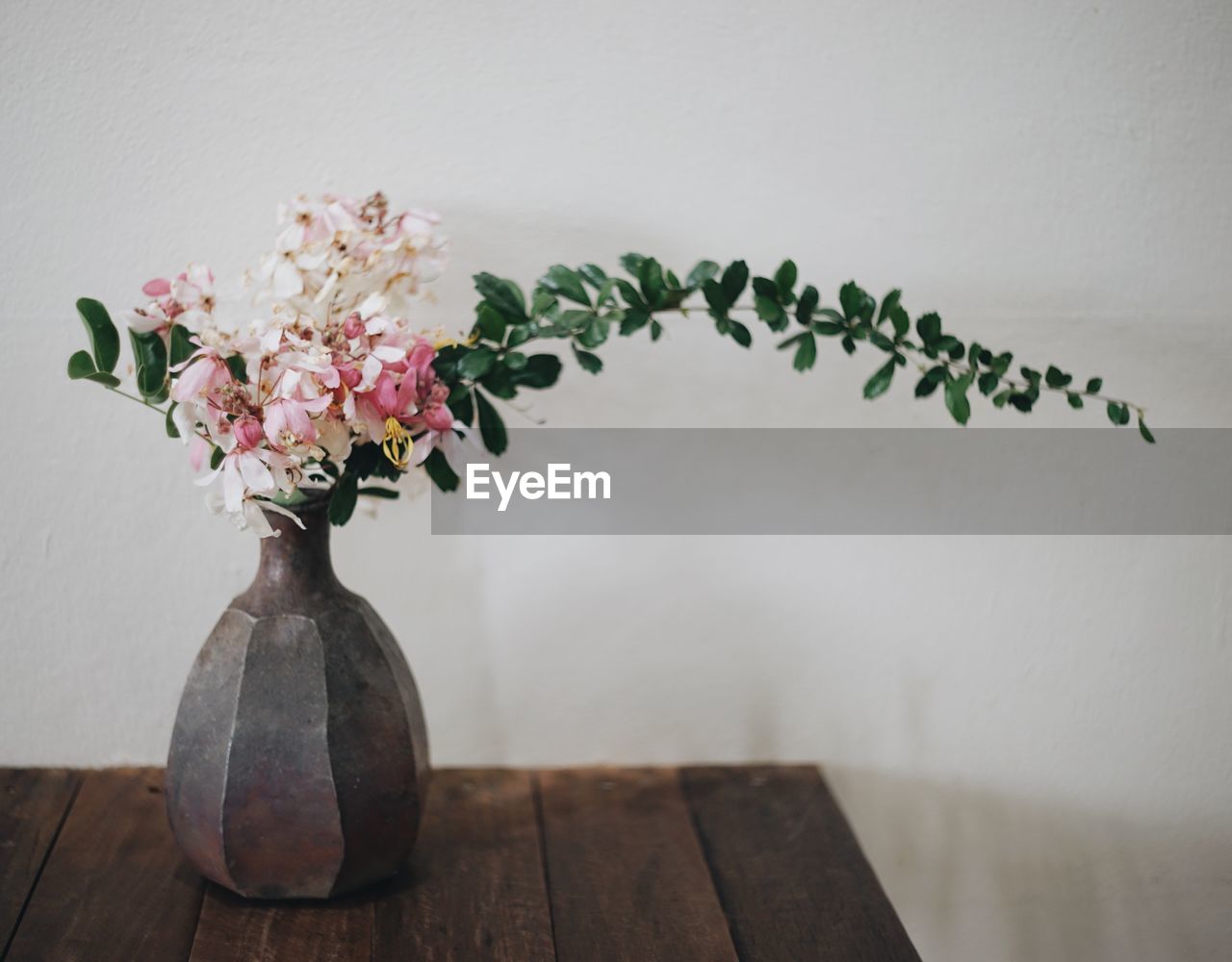 CLOSE-UP OF FLOWER VASE ON TABLE